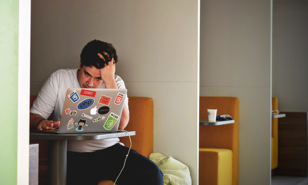 A man sitting at a table with a laptop.